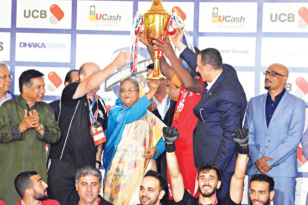 Prime Minister Sheikh Hasina handing over the trophy of Bangabandhu Gold Cup 2018 to champions Palestine skipper Abdallatif MS Albahdari in the presence of Palestinian Charge d'Affaires in Dhaka Yousuf S Ramada on Friday at the Bangabandhu National Stadium in Dhaka.	photo: Observer