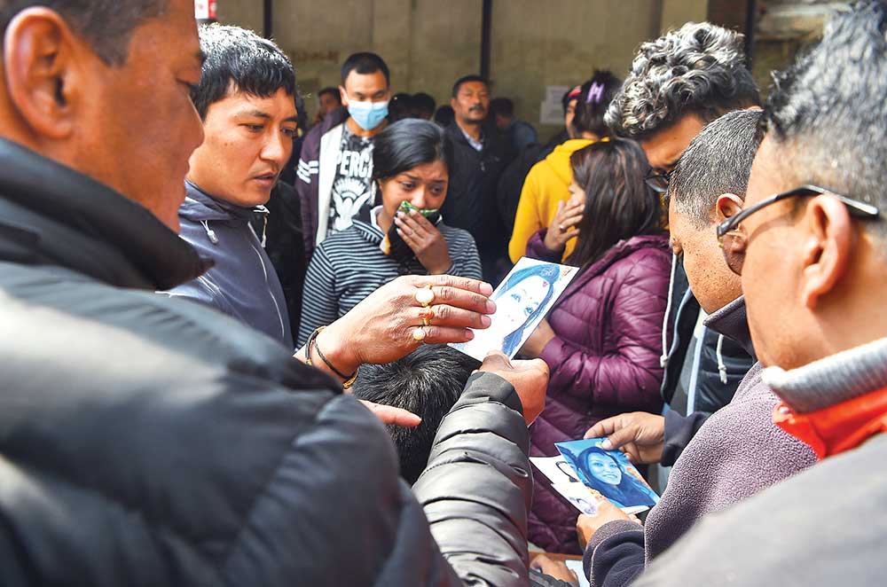 Family members of the plane crash victim hold pictures of their loved ones outside a morgue at the Teaching Hospital in Kathmandu on Tuesday, a day after the deadly crash of US-Bangla  plane in Nepal.	photo : AFP