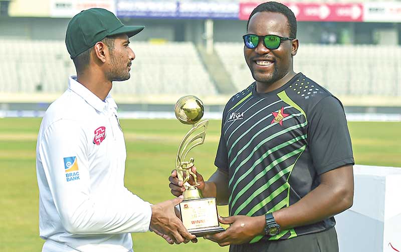 Bangladesh cricket captain Mohammad Mahmudullah (L) and Zimbabwe cricket captain Hamilton Masakadza (R) hold the tournament trophy following a presentation ceremony during the fifth day of the second Test cricket match at the Sher-e-Bangla National Cricket Stadium  in Dhaka on Thursday. 	photo: AFP 