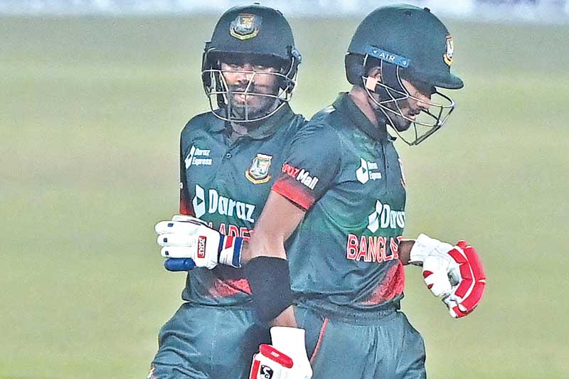 Bangladesh's Mehidy Hasan Miraz (L) with Afif Hossain run between the wickets during the first one-day international (ODI) cricket match between Afghanistan and Bangladesh at the Zahur Ahmed Chowdhury Stadium in Chittagong on February 23, 2022. 	PHOTO: AFP