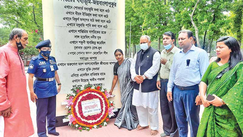 A floral wreath being placed on the Mass Graveyard Monument in Gopalganj Town on Friday morning to mark the Genocide Day-2022.	photo: observer
