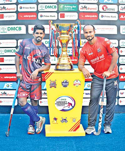 Monarch Padma captain Imran Hasan Pintu and ACME Chattogram captain Rezaul Karim Babu posing with the champions' trophy of the Hockey Champions Trophy ahead of the final on Wednesday.	photo: BHF