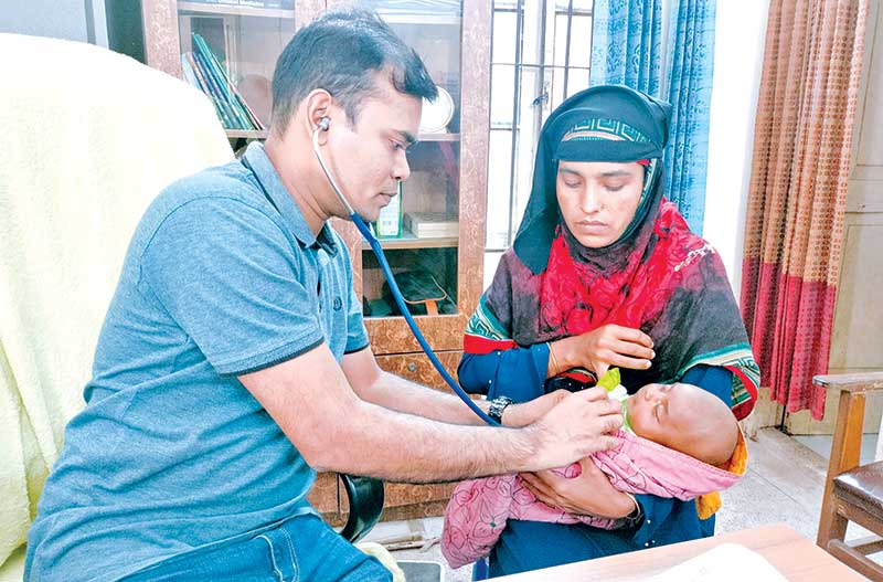 Lalmohan Upazila Health Complex RMO Dr Mahsin Khan providing treatment to a diarrhoea-affected child.	photo: observer