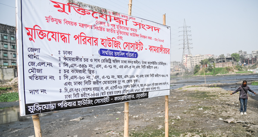 A signboard bearing the text 'Freedom Fighter Family Housing Society - Kamrangirchar' has been installed in the middle of a large canal of the Buriganga River near Kamrangirchar embankment in Dhaka. Photo: Sumit Ahmed