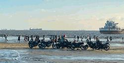 Bikes ride on beach sands after parking fee payment