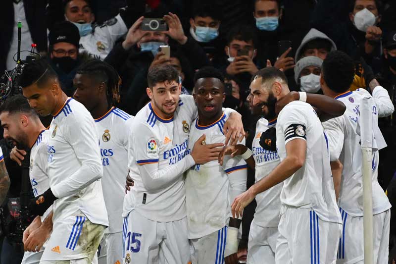 Real Madrid's Brazilian forward Vinicius Junior (C) is congratulated by teammates after scoring a goal during the Spanish league football match between Real Madrid CF and Sevilla FC at the Santiago Bernabeu stadium in Madrid on November 28, 2021. 	photo: AFP 