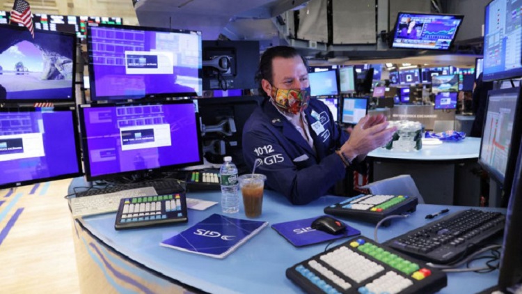 A trader works on the trading floor at the New York Stock Exchange (NYSE) in Manhattan, New York City, US, 28 December, 2021. Photo: Reuters/Andrew Kelly