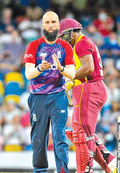 Moeen Ali (L) of England celebrates the dismissal of Odean Smith (R) of West Indies during the 2nd T20I between West Indies and England at Kensington Oval, Bridgetown, Barbados, on January 23, 2022. 	photo: AFP 