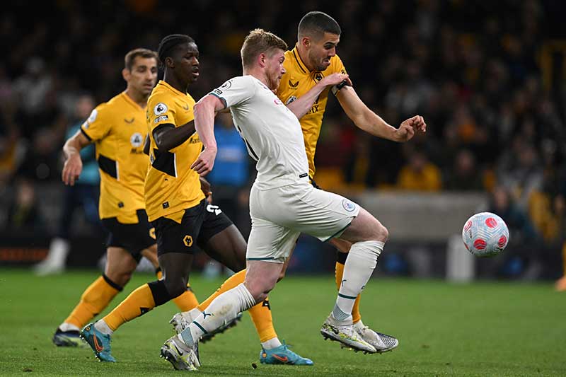 Manchester City's Belgian midfielder Kevin De Bruyne (C) fights for the ball with Wolverhampton Wanderers' English defender Conor Coady (rear R) during the English Premier League football match between Wolverhampton Wanderers and Manchester City at the Molineux stadium in Wolverhampton, central England on May 11, 2022.	photo: AFP 