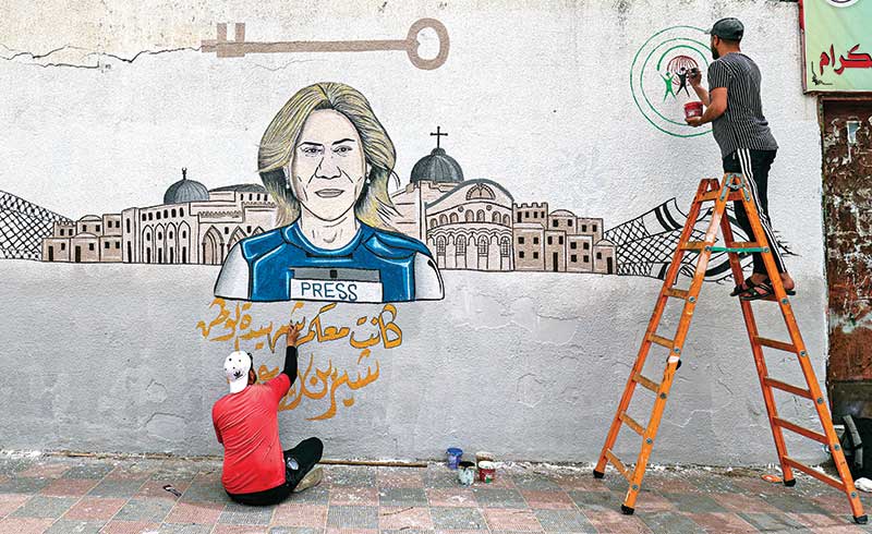 Palestinian artists paint a mural honouring slain veteran Al-Jazeera journalist Shireen Abu Akleh, in Khan Younis in the southern Gaza Strip, on May 14.    photo : AFP