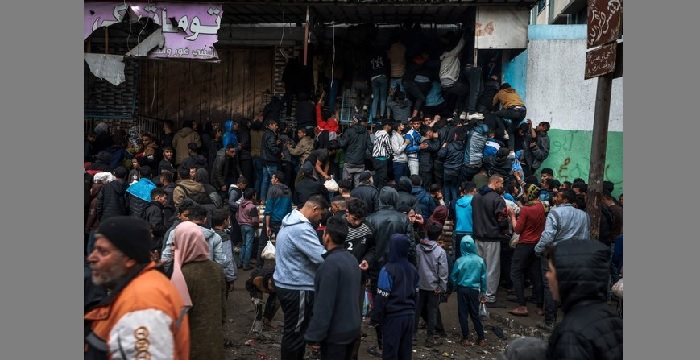 Palestinians crowd oustide a bakery to buy bread in Rafah on the southern Gaza Strip (AFP)