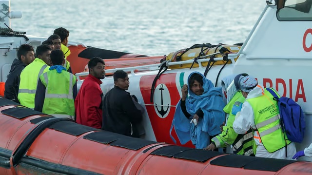 Migrants who survived a deadly shipwreck in the central Mediterranean listen as they wait to disembark in the Sicilian harbour of Pozzallo, Italy, Mar 13, 2023. FILE PHOTO REUTERS/Antonio Parrinello