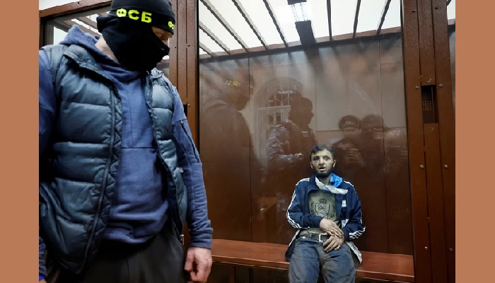 Dalerdzhon Mirzoyev, a suspect in the shooting attack at the Crocus City Hall concert venue, sits behind a glass wall enclosure at the Basmanny District Court in Moscow on Sunday. (Shamil Zhumatov/Reuters)