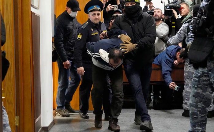 Rachabalizoda is escorted by authorities in the Basmanny District Court in Moscow on Sunday. (Alexander Zemlianichenko/The Associated Press)