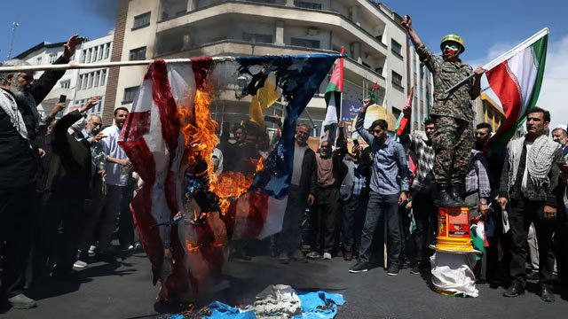 Iranians burn the US flag during a rally marking Quds Day and the funeral of members of the Islamic Revolutionary Guard Corps who were killed in a suspected Israeli airstrike on the Iranian embassy complex in the Syrian capital Damascus, in Tehran, Iran, Apr 5, 2024. Majid Asgaripour/WANA (West Asia News Agency) via Reuters