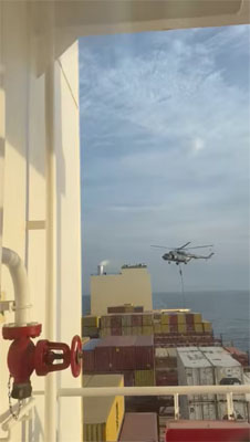 An official slides down a rope during a helicopter raid on MSC Aries ship at sea in this screen grab obtained from a social media video released on April 13, 2024. Video obtained by Reuters