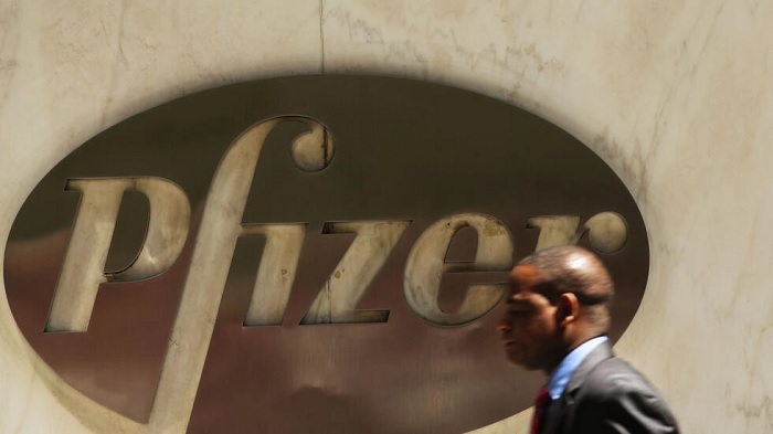 People walk past the Pfizer logo on their world headquarters in Manhattan © SPENCER PLATT / GETTY IMAGES NORTH AMERICA/AFP/File 