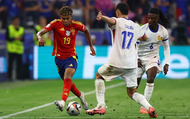 Euro 2024 - Semi Final - Spain v France - Munich Football Arena, Munich, Germany - July 9, 2024 Spain's Lamine Yamal in action with France's William Saliba and Eduardo Camavinga. Photo: REUTERS