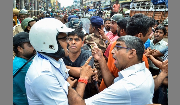 A BJP supporter scuffles with a police officer. Image Credit: ANI