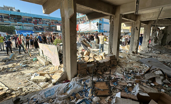 Palestinians inspect a school sheltering displaced people, after it was hit by an Israeli strike, amid the Israel-Hamas conflict, in Nuseirat in the central Gaza Strip. (File/Reuters)