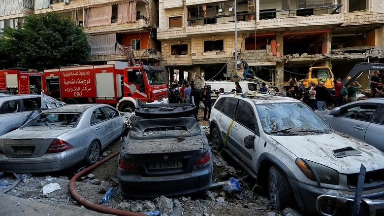 People gather near a firetruck and damaged vehicles at the site of Friday's Israeli strike, as search and rescue operations continue, in Beirut's southern suburbs, Lebanon September 21, 2024. (Reuters)