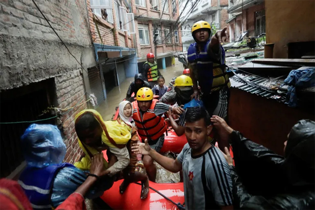 Security force members use an inflatable raft to bring residents to safety, from a flooded area near the bank of the overflowing Bagmati River, following heavy rains in the capital Kathmandu, September 28, 2024 [Navesh Chitrakar/Reuters]