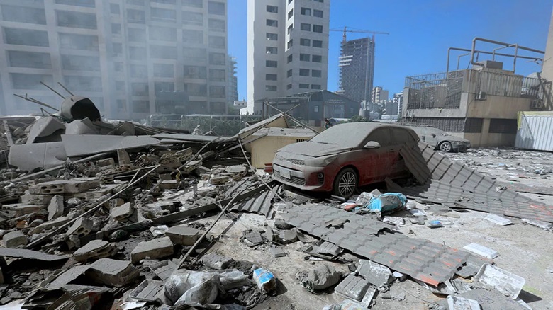 A destroyed car as smoke billows from the site of an Israeli airstrike on a neighbourhood in Beirut's southern suburbs on October 2, 2024. Photo: AFP