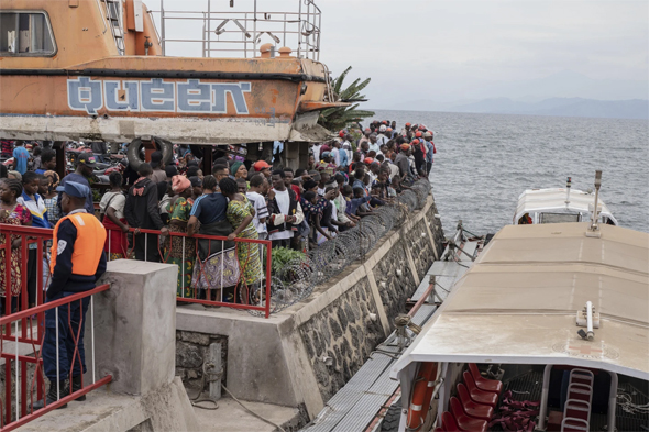 People gather at the port of Goma, Democratic Republic of Congo, after a ferry carrying hundreds capsized on arrival Thursday, October 3, 2024. (AP Photo/Moses Sawasawa)