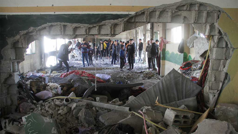  Palestinians inspect the site of an Israeli strike on a school sheltering displaced people, amid the Israel-Hamas conflict, in Gaza City December 14, 2024. REUTERS/Mahmoud Issa 