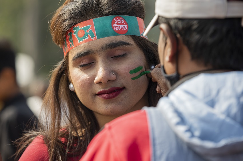 A young woman was seen applying colour of the victory on her cheek. Photo: AR Sumon