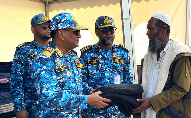 Director General of the Bangladesh Coast Guard (BCG) Rear Admiral Md Ziaul Haque hands over winter clothe to a man at Shah Porir Island in Teknaf of Cox’s Bazar on Wednesday. Photo: Collected 