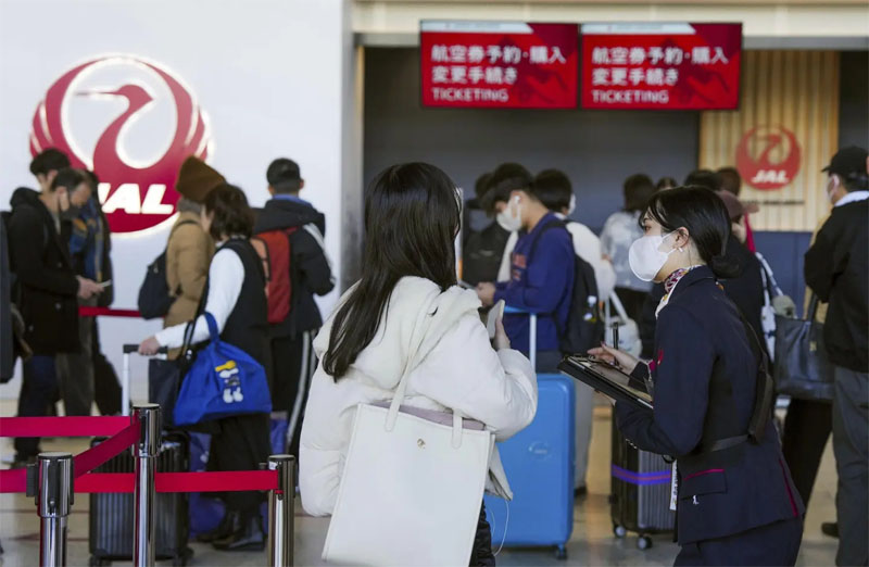 A staff member of Japan Airlines helps customers at Osaka International Airport on the outskirts of Osaka, western Japan on Thursday after the aitlines said it was hit by a cyberattack. Photo: AP