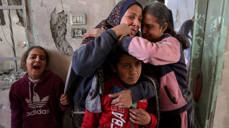 A woman and children react at the site of an Israeli strike in a residential area in the Tuffah neighbourhood, east of Gaza City, on December 26, 2024. © Omar Al-Qattaa, AFP  