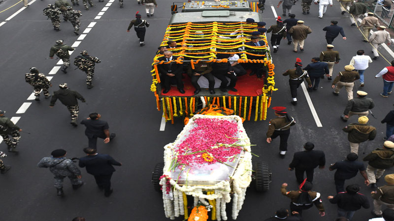  Security officials and others walk with the hearse carrying the body of former Indian Prime Minister Manmohan Singh towards the cremation site in New Delhi, India, Saturday, Dec. 28, 2024. Photo: AP