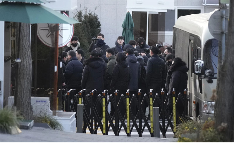 Investigators from the Corruption Investigation Office for High-ranking Officials arrive at the gate of the presidential residence as supporters of impeached South Korean President Yoon Suk Yeol stage a rally to oppose a court having issued a warrant to detain Yoon, in Seoul, South Korea, Friday, Jan. 3, 2025. (AP Photo/Lee Jin-man)