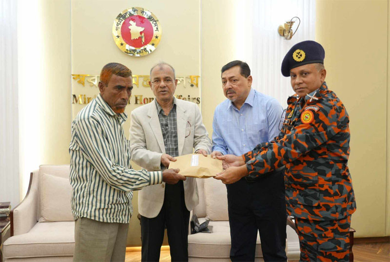 Home Affairs Adviser Lt Gen Md Jahangir Alam Chowdhury (retd) hands over the amount of the assistance to Nayan's father Md. Akhtaruzzaman at his office at the Secretariat on Monday afternoon. Photo: Home Ministry.